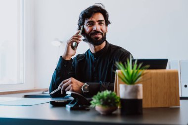 Ofisteki Pakistanlı iş adamı. Geleneksel kıyafetleri olan genç bir iş adamı ofisinde çalışıyor..