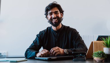 Ofisteki Pakistanlı iş adamı. Geleneksel kıyafetleri olan genç bir iş adamı ofisinde çalışıyor..