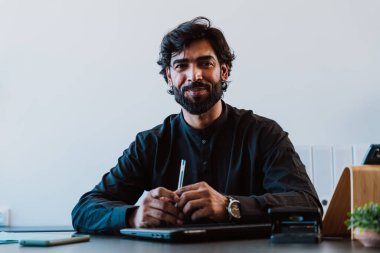 Ofisteki Pakistanlı iş adamı. Geleneksel kıyafetleri olan genç bir iş adamı ofisinde çalışıyor..