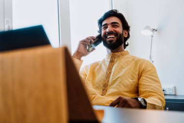 Ofisteki Pakistanlı iş adamı. Ofisinde geleneksel kıyafetleriyle çalışan genç bir iş adamı. Satış elemanı müşterilerle yeni anlaşmalar hakkında konuşuyor..