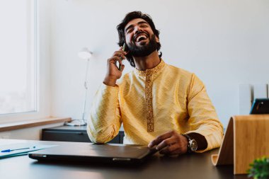 Ofisteki Pakistanlı iş adamı. Ofisinde geleneksel kıyafetleriyle çalışan genç bir iş adamı. Satış elemanı müşterilerle yeni anlaşmalar hakkında konuşuyor..