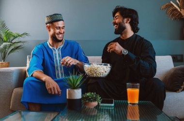 İki arkadaş evde film izleyip patlamış mısır yiyerek vakit geçiriyorlar..