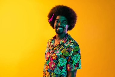 Renkli arka planda Afrikalı adam portresi - şık giyinen havalı siyah erkek, yaratıcı renkli ışıklandırma