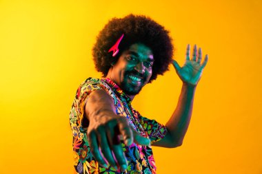 Renkli arka planda Afrikalı adam portresi - şık giyinen havalı siyah erkek, yaratıcı renkli ışıklandırma