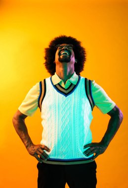 Renkli arka planda Afrikalı adam portresi - şık giyinen havalı siyah erkek, yaratıcı renkli ışıklandırma