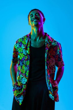 Renkli arka planda Afrikalı genç adam portresi - şık giyinen, yaratıcı renkli ışıklandırmalı havalı siyahi erkek