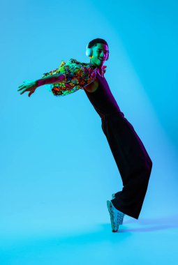 Renkli arka planda Afrikalı genç adam portresi - şık giyinen, yaratıcı renkli ışıklandırmalı havalı siyahi erkek