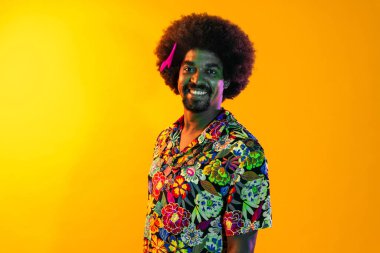 Renkli arka planda Afrikalı adam portresi - şık giyinen havalı siyah erkek, yaratıcı renkli ışıklandırma