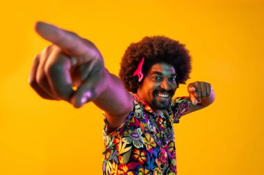 Renkli arka planda Afrikalı adam portresi - şık giyinen havalı siyah erkek, yaratıcı renkli ışıklandırma