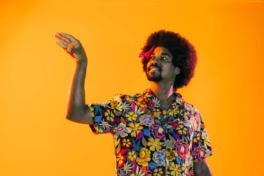 Renkli arka planda Afrikalı adam portresi - şık giyinen havalı siyah erkek, yaratıcı renkli ışıklandırma