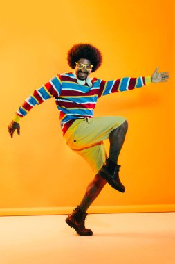 Renkli arka planda Afrikalı adam portresi - şık giyinen havalı siyah erkek, yaratıcı renkli ışıklandırma