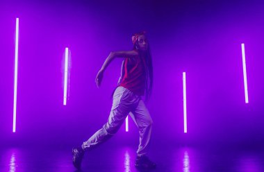 Neon ışıkları olan havalı bir stüdyoda hip hop dansçısı..