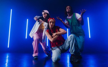 Bir grup hip hop dansçısı neon ışıklarıyla kasvetli bir stüdyoda dans ediyorlar..
