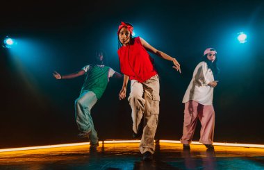 Bir grup hip hop dansçısı neon ışıklarıyla kasvetli bir stüdyoda dans ediyorlar..