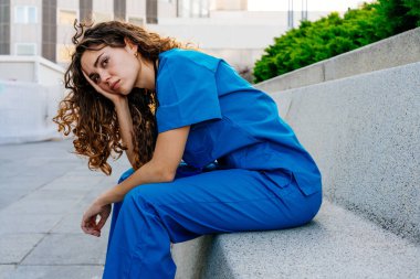 Hastanede mavi üniformalı güzel bir hemşire şehirde geziyor neşeli beyaz bir kadın doktor hastanede çalışıyor.