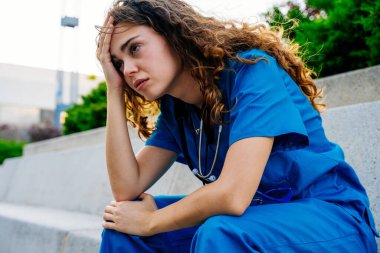 Hastanede mavi üniformalı güzel bir hemşire şehirde geziyor neşeli beyaz bir kadın doktor hastanede çalışıyor.