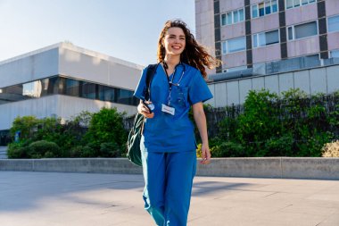 Hastanede mavi üniformalı güzel bir hemşire şehirde geziyor neşeli beyaz bir kadın doktor hastanede çalışıyor.
