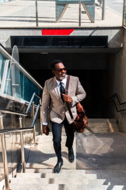 Şehirde gezen şık takım elbiseli, olgun siyahi işadamı, gri sakallı, son sınıf öğrencisi bir Afrikalı.