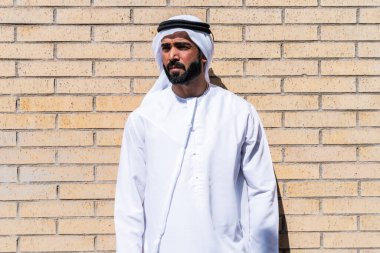 Geleneksel emirati kandura giyen yakışıklı Arap işadamının portresi.