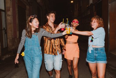 Bir grup arkadaş akşam dışarı çıkıp parti yapıyorlar. Gençler hafta sonları dışarıda buluşup renkli kokteyllerle kutlama yapıyorlar. Ön flaş fotoğraf biçimi.