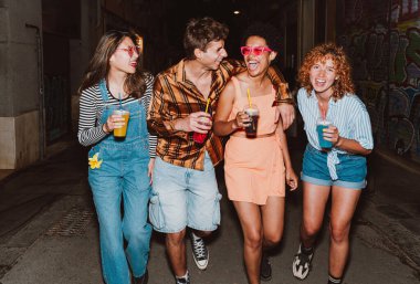 Bir grup arkadaş akşam dışarı çıkıp parti yapıyorlar. Gençler hafta sonları dışarıda buluşup renkli kokteyllerle kutlama yapıyorlar. Ön flaş fotoğraf biçimi.