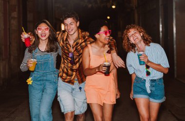 Bir grup arkadaş akşam dışarı çıkıp parti yapıyorlar. Gençler hafta sonları dışarıda buluşup renkli kokteyllerle kutlama yapıyorlar. Ön flaş fotoğraf biçimi.