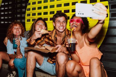 Arkadaşların akşam dışarı çıkıp parti yapıyor. Gençler hafta sonları dışarıda buluşup renkli kokteyller ve pizzayla kutlama yapıyorlar. Ön flaş fotoğraf biçimi.