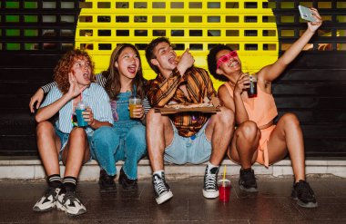 Arkadaşların akşam dışarı çıkıp parti yapıyor. Gençler hafta sonları dışarıda buluşup renkli kokteyller ve pizzayla kutlama yapıyorlar. Ön flaş fotoğraf biçimi.