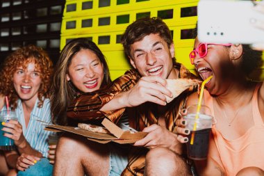 Arkadaşların akşam dışarı çıkıp parti yapıyor. Gençler hafta sonları dışarıda buluşup renkli kokteyller ve pizzayla kutlama yapıyorlar. Ön flaş fotoğraf biçimi.