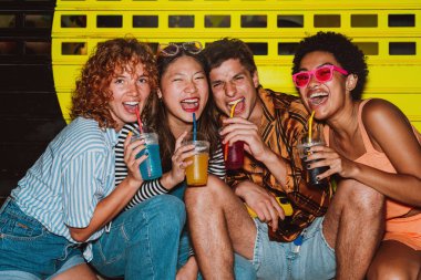 Arkadaşların akşam dışarı çıkıp parti yapıyor. Gençler hafta sonları dışarıda buluşup renkli kokteyllerle kutlama yapıyorlar. Ön flaş fotoğraf biçimi.