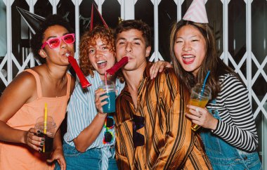 Arkadaşların akşam dışarı çıkıp parti yapıyor. Gençler hafta sonları dışarıda buluşup renkli kokteyllerle kutlama yapıyorlar. Ön flaş fotoğraf biçimi.