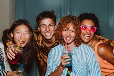 Arkadaşların akşam dışarı çıkıp parti yapıyor. Gençler hafta sonları dışarıda buluşup renkli kokteyllerle kutlama yapıyorlar. Ön flaş fotoğraf biçimi.