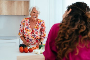 Güzel büyükanne ve torun evde birlikte yemek pişiriyor neşeli büyükanne ve yeğen birlikte vakit geçiriyorlar.
