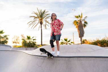 Paten parkında kaykay yapan güzel, aktif bir son sınıf öğrencisi kadın kaykaycı olgun bir kadın kaykaycı eğleniyor, yaşlılar, modern yaşam tarzı ve yeşil hareketlilik kavramları var.