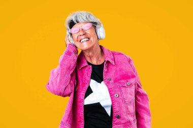 Stüdyoda gri saçlı, şık giyimli güzel bir kadın, şık bir tarzı olan neşeli, yaşlı bir büyükanne.