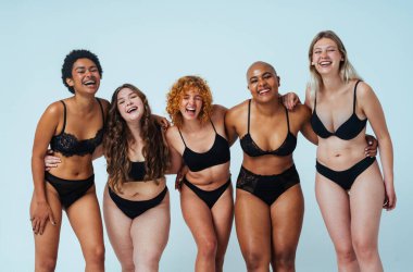 Çeşitliliği ve kendine saygıyı kutlamak için stüdyoda poz veren çok ırklı kadın iç çamaşırı giyen bir grup kadın. Vücut pozitifliği, özgünlük, kadın gücü ve beden kabulü kavramları.