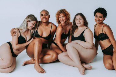 Çeşitliliği ve kendine saygıyı kutlamak için stüdyoda poz veren çok ırklı kadın iç çamaşırı giyen bir grup kadın. Vücut pozitifliği, özgünlük, kadın gücü ve beden kabulü kavramları.