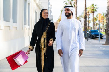 Geleneksel Arap çift açık havada buluşan emirati kıyafetleri giyiyorlar - Orta Doğulu evli kadın ve abaya ile erkek kandura buluşması ve şehirde eğleniyorlar