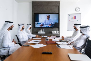 İş anlaşması için emirati kandura giyen Arap işadamları, Orta Doğu 'da uluslararası bir şirkette çalışan orta doğulu kurumsal iş adamları grubu.