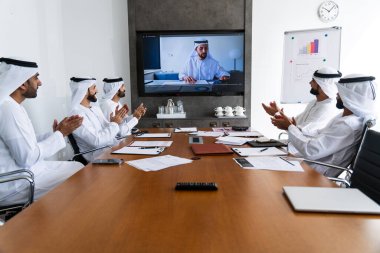 İş anlaşması için emirati kandura giyen Arap işadamları, Orta Doğu 'da uluslararası bir şirkette çalışan orta doğulu kurumsal iş adamları grubu.