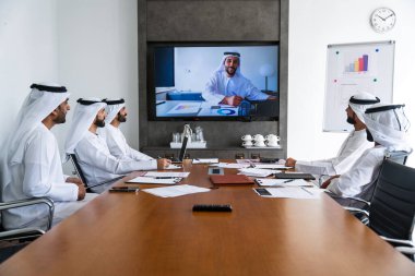 İş anlaşması için emirati kandura giyen Arap işadamları, Orta Doğu 'da uluslararası bir şirkette çalışan orta doğulu kurumsal iş adamları grubu.