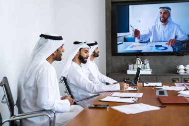 İş anlaşması için emirati kandura giyen Arap işadamları, Orta Doğu 'da uluslararası bir şirkette çalışan orta doğulu kurumsal iş adamları grubu.