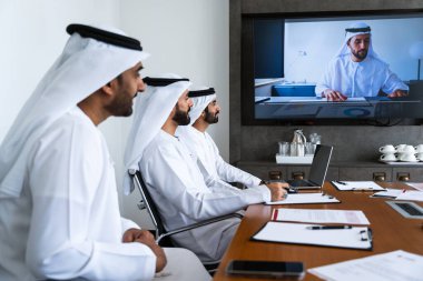 İş anlaşması için emirati kandura giyen Arap işadamları, Orta Doğu 'da uluslararası bir şirkette çalışan orta doğulu kurumsal iş adamları grubu.