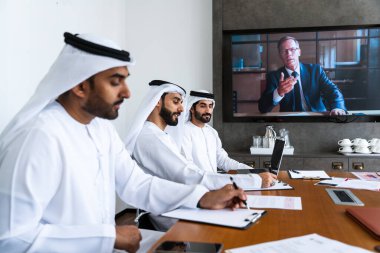 İş anlaşması için emirati kandura giyen Arap işadamları, Orta Doğu 'da uluslararası bir şirkette çalışan orta doğulu kurumsal iş adamları grubu.