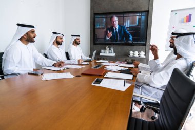 İş anlaşması için emirati kandura giyen Arap işadamları, Orta Doğu 'da uluslararası bir şirkette çalışan orta doğulu kurumsal iş adamları grubu.