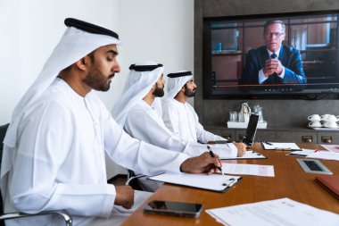 İş anlaşması için emirati kandura giyen Arap işadamları, Orta Doğu 'da uluslararası bir şirkette çalışan orta doğulu kurumsal iş adamları grubu.