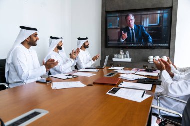 İş anlaşması için emirati kandura giyen Arap işadamları, Orta Doğu 'da uluslararası bir şirkette çalışan orta doğulu kurumsal iş adamları grubu.