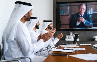 İş anlaşması için emirati kandura giyen Arap işadamları, Orta Doğu 'da uluslararası bir şirkette çalışan orta doğulu kurumsal iş adamları grubu.