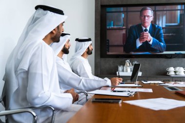 İş anlaşması için emirati kandura giyen Arap işadamları, Orta Doğu 'da uluslararası bir şirkette çalışan orta doğulu kurumsal iş adamları grubu.