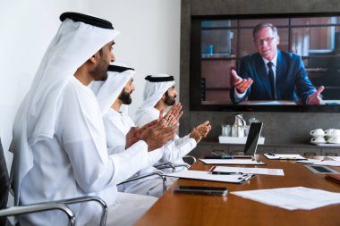 İş anlaşması için emirati kandura giyen Arap işadamları, Orta Doğu 'da uluslararası bir şirkette çalışan orta doğulu kurumsal iş adamları grubu.